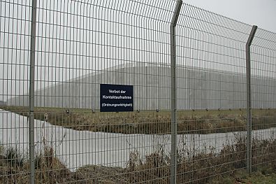 04_22871 -usserer Drahtzaun, Wassergraben und Gefngnismauer.