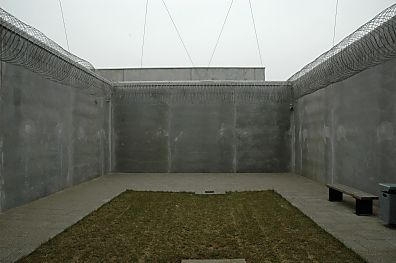 04_22881 - mit ca. 6m hohen Mauern und Stacheldraht umschlossener Hof fr den Aufenthalt von Gefangenen; das Areal ist mit Drhten berspannt, die eine Befreiung der Insassen durch den Einsatz durch Hubschrauber abwehren soll. 
