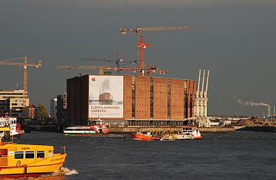 011_15421 das denkmalgeschtzte Gebude vom Kaispeicher in der Abendsonne; auf der Elbe fahren die Elbfhren ihre Passagiere - im Hintergrund die Baukrne der Hafencity.