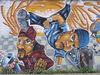 Graffiti an einer Hauswand; ein Rapper mit Ghetto-Blaster und ein Sprayer mit Spraydose.