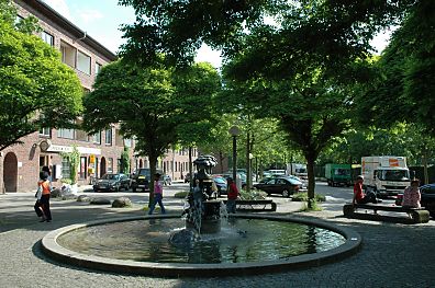 Kinder spielen am Brunnen