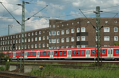 S-Bahnzug vor den Wohnhusern auf der Veddel