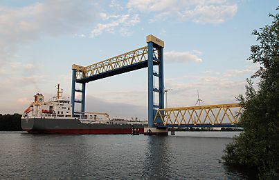 011_15880 - ein grosser Frachter fhrt unter der Brcke hindurch - die Hubbrcke ist auf ihre maximale Hhe von 54m hochgefahren, damit das Schiff problemlos durch passt.