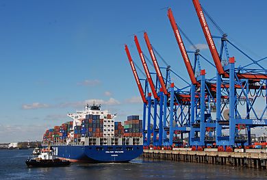 011_15453 - der hochbeladene Containerfrachter wird in die Fahrrinne gezogen; re. die hochgeklappten Ausleger der Containerbrcke.