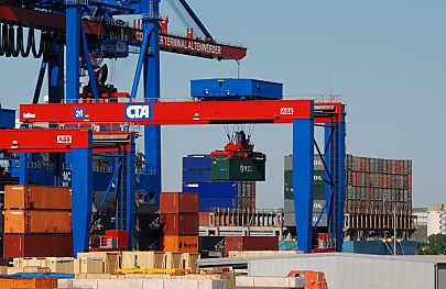 011_15651 - die Container werden von den Transportfahrzeugen mit einem beweglichen Kran in das Containerlager gebracht - im Hintergrund das Heck des Containerschiffs, das gelscht wird.