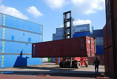 011_15716 - ein Container - Carrier bringt einen 40 ft. vom Lagerplatz; links und rechts sind die Container in mehreren Lagen gestapelt. 