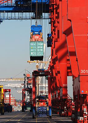 11_15753 -ein TEU Container (TEU = Twenty - feet Equivalent Units ) wird von der Containerbrcke an Land gebracht - ein Portalstapelwagen wartet auf seine Fracht.
