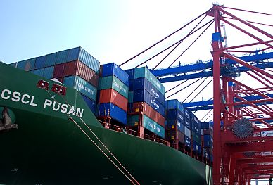 11_15770 - Schriftzug der CSCL PUSAN und die hoch gestapelten Container auf dem Schiffsdeck.