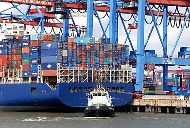 011_15695 - die Container sind auf dem Heck des Schiffs auf mehreren Ebenen hoch gestapelt; ein Schlepper wird das Schiff von dem Liegeplatz im Hafen Hamburgs am Terminal Burchardkai weg ziehen.