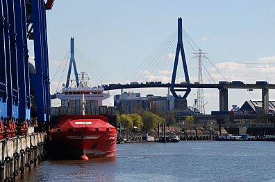 011_15705 - ein leerer Container Feeder am Burchardkai; im Hintergrund die stark befahrene Hochbrcke die den Khlbrand berquert Khlbrandbrcke .