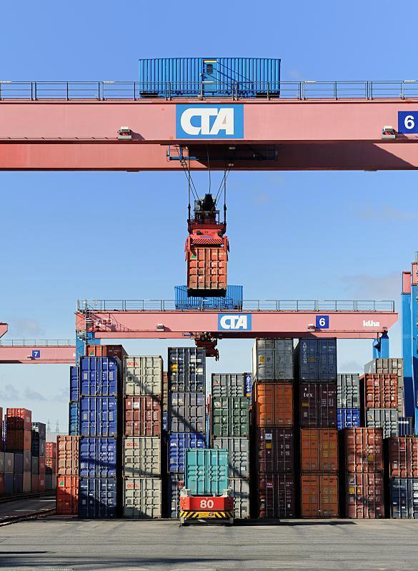 Fotodokumentation: Arbeit im Hamburger Hafen - Container Terminal Container - Krananlage / Containerlager.  85_0086 Ein Container wird vom Kran an seinen Lagerplatz auf einem der  26 Lagerblcken gebracht. Die Krananlage auf dem Betriebsgelnde des Terminals Altenwerder besteht aus zwei unabhngig voneinander arbeitenden Krnen (Double Rail Mounted Gantry – DRMG). Durch ihre unterschiedliche Gre knnen beide Krne simultan ber den gesamten Block arbeiten, der kleinere Kran fhrt einfach unter dem greren durch.