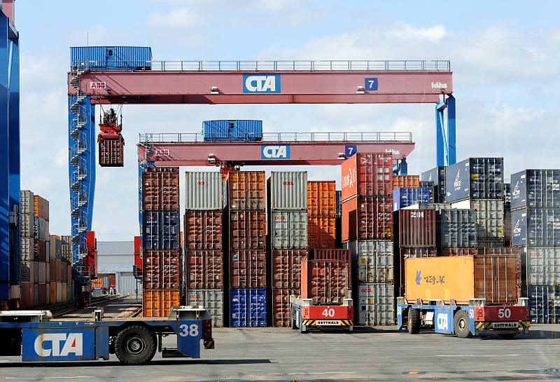 otos aus dem Hamburger Hafen - vom Containerlager, Portalkranpaar Terminal Altenwerder Double-Rail-Mounted-Gantry-DRM - Portalkranpaar + Automated Guieded Vehicles AGV.  88_1138 Die Automated Guided Vehicle AGV transportieren die Container von der Containerbrcke am Hafenkai zur Zwischenlagerung zu den Portalkrnen vor dem Lagerblock. Die Portalkranpaare (Double Rail Mounted Gantry – DRMG), bestehen aus zwei unabhngig voneinander arbeitenden Krnen, so dass gleichzeitig die Seeseite mit den AGV und die gegenberliegende Seite mit den Bahn und LKW bedient werden knnen. Durch ihre unterschiedliche Gre knnen beide Krne simultan ber den gesamten Block arbeiten, der kleinere Kran fhrt einfach unter dem greren durch.