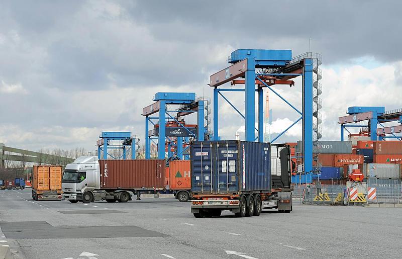 Bilder vom Güterumschlag - Containertransport, HHLA Terminal Altenwerder. Sattelzüge mit Containerchassis - Containerhafen Hamburg Altenwerder. 94_0252 Die mit den Containern beladenen Sattelkraftfahrzeuge manövrieren ihre Fahrzeuge aus dem Ladeplatz unter den Portalkränen heraus und bringen ihre Ladung zur Zollstelle auf dem Terminalgelände.