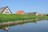 021_4078 Bauernhuser und Wohnhuser sind mit einem Deich vor der berflutung durch Hochwasser der Lhe geschtzt.  Historische reetgedeckte Fachwerkhuser und Klinkerhuser stehen entlang des 12,7 km langen Flusses des Alten Landes. Die Giebel der Huser spiegeln sich im ruhigen Wasser.