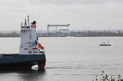 011_15401 Blick von Blankenese ber die Elbe zum Estesperrwerk in Cranz; ein Frachtschiff fhrt Richtung Hafen Hamburg, ein Tonnenleger macht seine Arbeit in der Fahrrinne der Elbe.