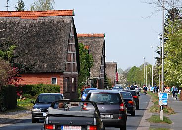 011_15521 - whrend der Kirschblte und Apfelblte besuchen viele Touristen das Obstanbaugebiet im Alten Land - die Autos fahren entlang der strohgedeckten Fachwerkhuser.