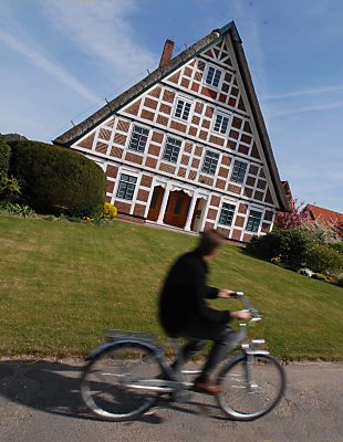 011_15525 - mit dem Fahrrad lsst sich das Alte Land mit seinen historischen Fachwerkgebude bei Sonnenwetter gut erkunden.