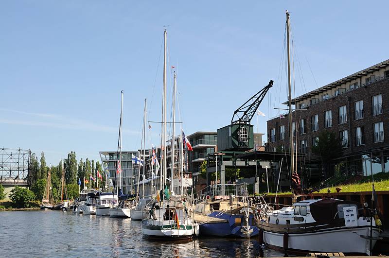 Motorboote und Segelyachten am Anleger Hafen Stade. Tourismus in der Metropolregion Hamburg / Hansestadt Stade.  081_8076 Sportboote haben an dem Schlengel im Stader Stadthafen fest gemacht. Die Gastlieger besuchen Stade auf ihrem Trn auf der Elbe. Am Ufer des Hafens wurden Wohn- und Brogebude errichtet - ein historischer Kran bleibt als Erinnerung an der Wirtschaftshafen erhalten. Lks. im Hintergrund die Industriearchitektur des Gasometers dam Stader Hafenrand.