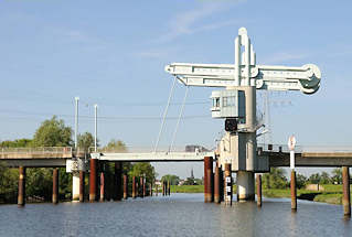 072_8054 Die Waagebalken- klappbrcke ber die Schwinge hat eine Spannweite von 29m - ein Brckenpegel zeigt die lichte Durchfahrtshhe an. Bei Bedarf wird die Brcke fr die Schifffahrt geffnet. Im Hintergrund der Kirchturm der Stader St. Cosmae- Kirche. 