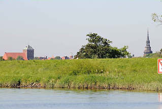 075_8058 Hinter dem grnen Deich der Schwinge sind Huser und die Kirchtrme der Hansestadt Stade zu erkennen. Rechts der Barock-Turm der St. Cosmae-Kirche, lks. die gotische St. Wilhadi-Kirche. 