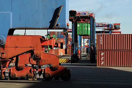 11_17420 - im Vordergrund die massiven Rollen auf denen sich die Containerbrcken bewegen, um das Containerschiff am Kai zu entladen. Zwischen den gelagerten Containern fahren die  Portalhubwagen mit ihrer Fracht zu dem betreffenden Lagerort.