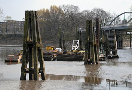 11_17466 - Bei Ebbe sind grosse Teile des Moldauhafen ver- schlickt; ein Ponton und Arbeitsboote liegen im Schlamm. Im Hintergrund die Sachsenbrcke und dahinter die Kirchturmspitze der Immanuelkirche und Huser das Hamburger Stadtteils Veddel.