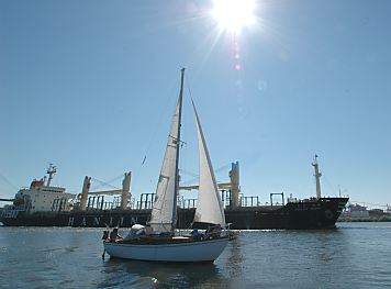 011_14254 - Segelschiff auf dem Khlbrand; dahinter verlsst ein Frachter den Hamburger Hafen.