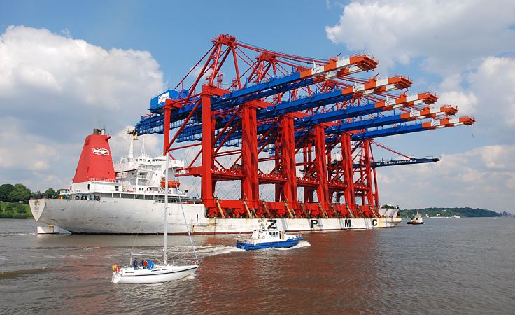 11_213889 Fnf neue Containerbrcken fr das Terminal EUROGATE werden per Schiff auf der Elbe angeliefert. Ein Schlepper zieht den  chinesischen Frachter Zhen Hua 20 im Fahrwasser des Hamburger Flusses. Polizeiboot der Hamburger Wasserschutzpolizei patrouilliert und achtet darauf, dass kein anderes Schiff die Fahrt mit den den grossen Ladebrcken strt. Ein Segelschiff fhrt mit Motorhilfe in sicherem Abstand vorbei.   www.bildarchiv-hamburg.de