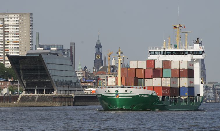 11_21390 Der Containerfeeder Cartagena verlsst hoch beladen den Hamburger Hafen. Im Hintergrund ist das Hamburger Wahrzeichen die St. Michaeliskirchr / Michel zu erkennen. Links die moderne Hamburger Architektur in Hamburg Neumhlen, das Dockland. Das Gebude am Elbufer wurde im Architekturbro , Richter, Teherani entworfen. www.bildarchiv-hamburg.de