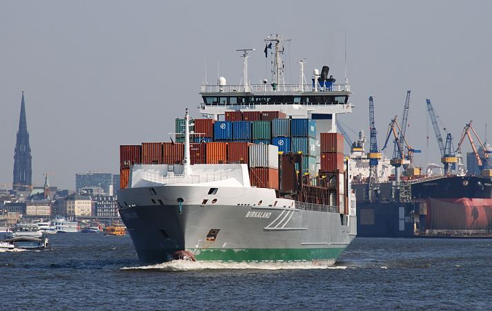 11_213891 Der Containerfeeder Birkaland wurde im Hamburger Hafen mit Containern beladen und fhrt jetzt elbabwrts. Rechts im Hintergrund liegt ein Tanker im Trockendock der Hamuburger Werft Blohm + Voss. Links ist der Turm der St. Nikolaikirche zu erkennen. www.bildarchiv-hamburg.de