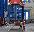 11_21405 Ein Container wird mit dem Containergreifer der Containerbrcke von der Laschplattform abgesenkt. Hafenarbeiter stehen auf dem Athabaskakai des Terminals Burchardkai und nehmen die Metallbox in Empfang.   www.bildarchiv-hamburg.de