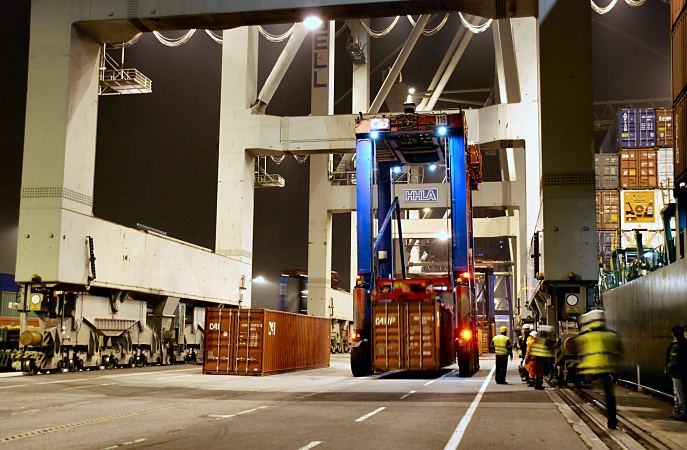 11_21416 Nachtarbeit im Hamburger Hafen; bei Beleuchtung werden die Container an den Containerbrcken abgestellt; die Brcken bewegen sich auf Rdern und Schienen auf der Kaianlage. Hafenarbeiter, die auf dem Containerterminal arbeiten mssen zumSchutz Helm und Signalweste tragen. www.bildarchiv-hamburg.de