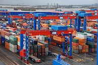 11_21434 Blick ber das Containerzwischenlager auf dem Gelnde des Container Terminals Hamburg Altenwerder. Vor dem Portalkranpaar (Double Rail Mounted Gantry – DRMG) stehen die fhrerlosen Transportfahrzeuge ( Automated guided Vehicles AGV ) und warten auf ihre Fracht, die sie dann zur Containerbrcke bringen. Auf dem Areal des Containerlagers werden die Container 4fach gestapelt, an der Aussenreihen stehen 5 der Stahlboxen bereinander.  www.bildarchiv-hamburg.de