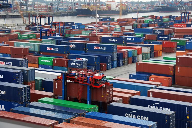 11_21437 Hafenmotive aus Hamburg - Hamburger Containerhafen / Terminal Burchardkai - Hafenfotos - :: Blick ber das Containerlager auf dem HHLA Gelnde des Container Terminals Burchardkai. Portalhubwagen / Containercarrier fahren durch die schmalen Gassen zwischen den gestapelten Containern und transportieren die  Fracht zu ihrem Bestimmungsort. Auf der anderen Seite des Waltershofer Hafenbeckens liegen Contianerfeeder am Predhlkai.  www.bildarchiv-hamburg.de