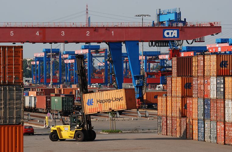 11_21443 Fotografie vom Containerlager Altenwerder - Containerstacker und Containerbahnhof Aus der dichten Reihe der gelagerten Container hat der Container Stapler seine Ladung heraus gezogen. Im Hintergrund ist der Containerbahnhof vom Terminal Altenwerder zu erkennen - mit Container beladene Gterwaggons stehen auf den Bahngleisen - die Portalkrane berspannen die gesamte Gleisanlage.  www.bildarchiv-hamburg.de