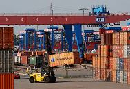 11_21443 Aus der dichten Reihe der gelagerten Container hat der Container Stapler seine Ladung heraus gezogen. Im Hintergrund ist der Containerbahnhof vom Terminal Altenwerder zu erkennen - mit Container beladene Gterwaggons stehen auf den Bahngleisen - die Portalkrane berspannen die gesamte Gleisanlage.  www.bildarchiv-hamburg.de