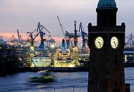 05_4525 Abenddämmerung über dem Hafen der Hansestadt Hamburg - die eingedockten Passagierschiffe sind beleuchtet - es wird die ganze Nacht an ihnen gearbeitet. Eine beleuchtete Hafenfähre kommt von Finkenwerder und steuert die Landungsbrücken an. Im Vordergrund die beleuchteten Uhren des Uhren- und Pegelturm an den St. Pauli Landungsbrücken.