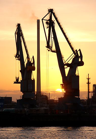 Sonnenuntergang im Hafen Hamburg - Krne als Silhouette im Gegenlicht.  08_x9833 Der Abendhimmel des Hamburger Hafens ist rot gefrbt - zwei hohe Hafenkrne stehen auf der Kaimauer am Ufer der Elbe. www.fotograf-hamburg.de