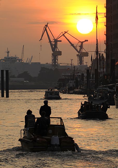 09_4936 Blick ber den Sandtorhafen, dem Hamburger Traditionsschiffhafen zur Elbe - Barkassen fahren in der Abenddmmerung ber das Wasser. Der Himmel ist rot gefrbt - Krne stehen auf der gegenberliegenden Seite des Flusses.  www.fotograf-hamburg.de Sonnenuntergang im Hamburger Hafen, Barkassen  Sonnenuntergang im Hafen Hamburg - Sandtorhafen / Hamburger Traditionsschiffhafen.