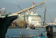 18_6826 Blick auf den Vordersteven und Bugspriet des Museumsschiffs RICKMER RICKMERS an den Hamburger Landungsbrcken. Auf dem Kverbaum des 1896 gebauten Frachtseglers weht die Hamburgfahne. Im Dock Elbe 17 liegt das Kreuzfahrtschiff FREEDOM OF THE SEAS; es werden Wartungsarbeiten an dem zweitgrten Passagierschiff der Welt vorgenommen. 