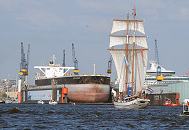 20_8173 Der 190m lange und 32m breite Tanker OCEAN COSMOS liegt im Schwimmdock 11 der Werft Blohm + Voss; Arbeitskrne stehen auf dem Werftgelnde der 1877 gegrndeten Hamburger Grosswerft. Ein Segelschiff fhrt unter Segel Richtung Landungsbrcken. 