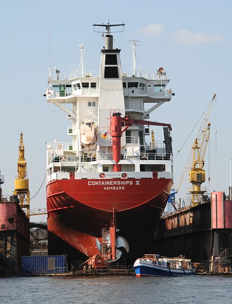 Bilder von der Arbeit im Hamburger Hafen. Fotoposter von Hamburg als GEschenk zum Jahrestag - Jubilum - Firmenabschied. 23_26-5959 Das Frachtschiff CONTAINERSHIPS V mit Heimathafen Hamburg im Dock der Norderwerft am Reiherstieg. Eine Barkasse der Hamburger Hafenrundfahrt fhrt an dem Heck des Containerfeeders vorbei. www.hamburg-bilder.org