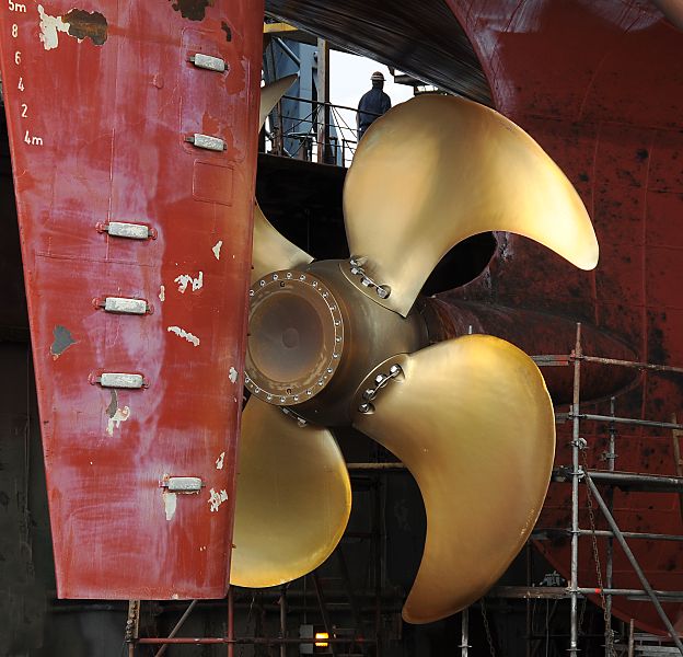 Hamburg-Fotos aus dem Hafen - Steuerruder und Schiffschraube. Fotoleinwand von Hamburgbildern als Geschenk zum Jahrestag - Jubilum - Firmenabschied. 30_x9840 Dem Frachter im Trockendock der Hamburger Werft wurde eine neue Schiffsschraube montiert. Die einzelnen Propellerteile sind mit schweren Schrauben / Nieten an dem Rumpf des Propellers befestigt. www.hamburg-bilder.org