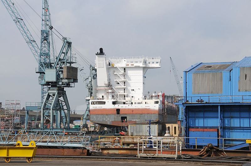 35_5131 Blick ber das Werftgelnde der Sietas-Werft. Ein Schiffsneubau liegt im Dock - groe Arbeitskrne knnen auf Schienen ber das Areal bewegt werden. www.fotos-hamburg.de Bilder der Hamburger J. J. Sietas KG Schiffswerft in Neuenfelde; Schiffsneubau.