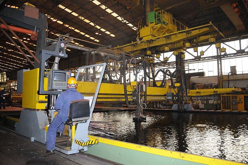 Bilder von der Arbeit im Hamburger Hafen + Elbe - Sietas Schiffswerft Neuenfelde. Fotoleinwand + Hamburg-Poster von Hamburgbildern als Geschenk zum Jahrestag - Jubilum - Firmenabschied. 40_5070 Ein Arbeiter der Sietas-Werft sitzt auf dem Fhrerstand einer Metall-Schneideanlage. Computer gesteuert wird der Stahl unter Wasser geschnitten. www.fotos-hamburg.de