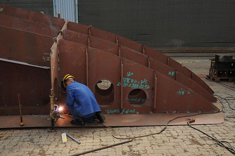 Hamburg - Fotografie von der Arbeit im Hafen -  Schweiarbeiten auf der Sietas Schiffswerft.  46_5147 Im Aussenbereich der Arbeitshalle schweit ein Werftarbeiter der Sietas KG ein Schiffssegment fr den Neubeu eines Containerfeeders zusammen.  www.fotos-hamburg.de