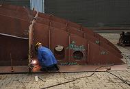 46_5147 Im Aussenbereich der Arbeitshalle schweißt ein Werftarbeiter der Sietas KG ein Schiffssegment für den Neubeu eines Containerfeeders zusammen.