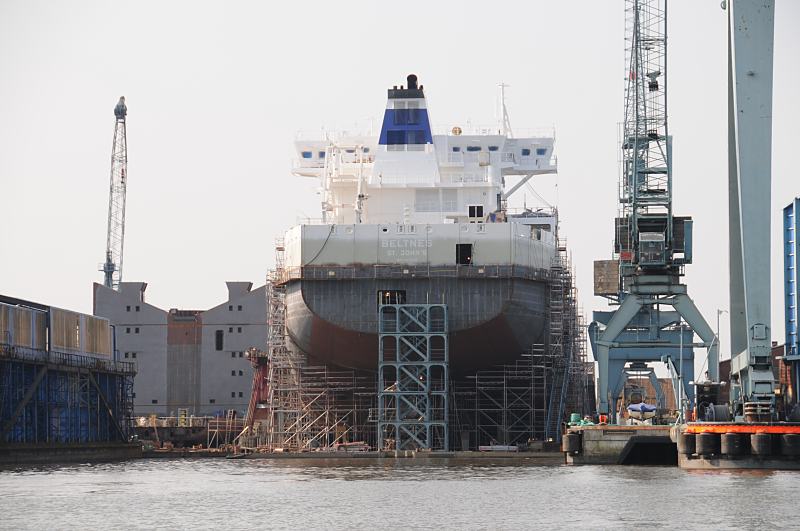 Hamburg-Fotografien von der Arbeit im Hafen - Schiffsneubau im Trockendock, Este. Fotoposter von Hamburg - Fotoleinwand als Geschenk zum Geburtstag - Andenken - Weihnachten.  48_5193 Blick von der Este auf ein Trockendock der Schiffswerft Sietas KG. An einem der letzten Containerschiffs- neubauten der Traditionswerft wird gerade gearbeitet - Gerste sind um den Rumpf des Schiffs aufgestellt. Ab Ende 2009 wurde konzentrierte sich die Werft auf den Neubau von Schwerlastschiffen und Fhren. www.fotos-hamburg.de