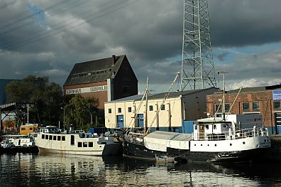 11_15786 - Schiffe am Lotsekai; am Ufer Lagergebude im Harburger Hafen und ein hoher Speicher - Gewitterwolken am Himmel. 