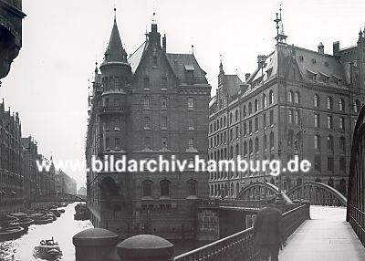 01_15783 - historisches Bild der Speicherstadt ca. 1930 von der Neuerwegsbrcke aus in den Brooksfleet gesehen. Schuten und Boote liegen an den Lagerhusern des Freihafens und werden entladen oder mit ihren Waren beladen.